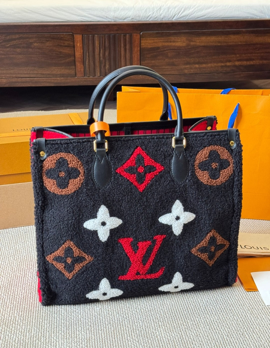 Designer handbag with patterned design on a surface with boxes in the background