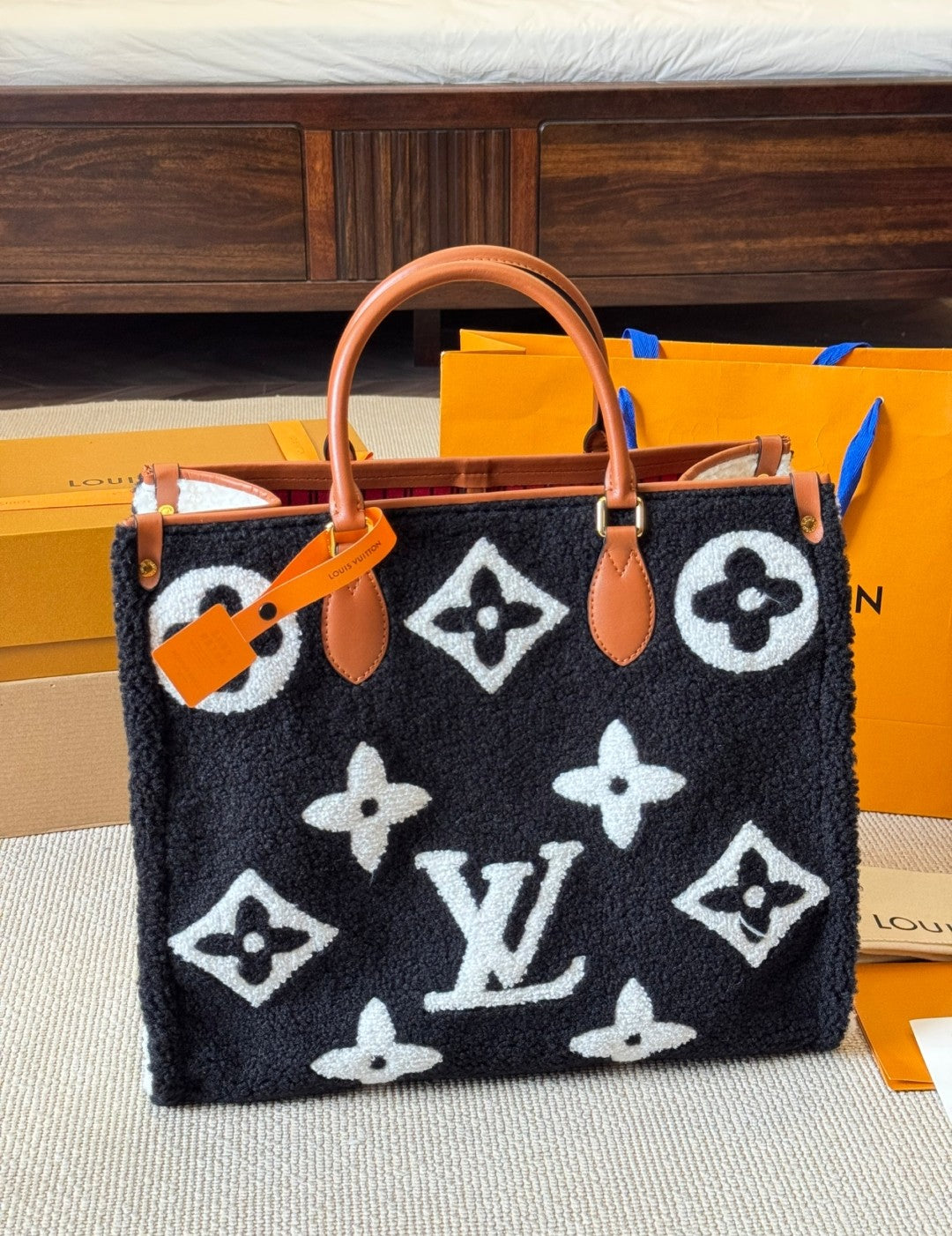 Designer handbag with monogram pattern on a neutral background