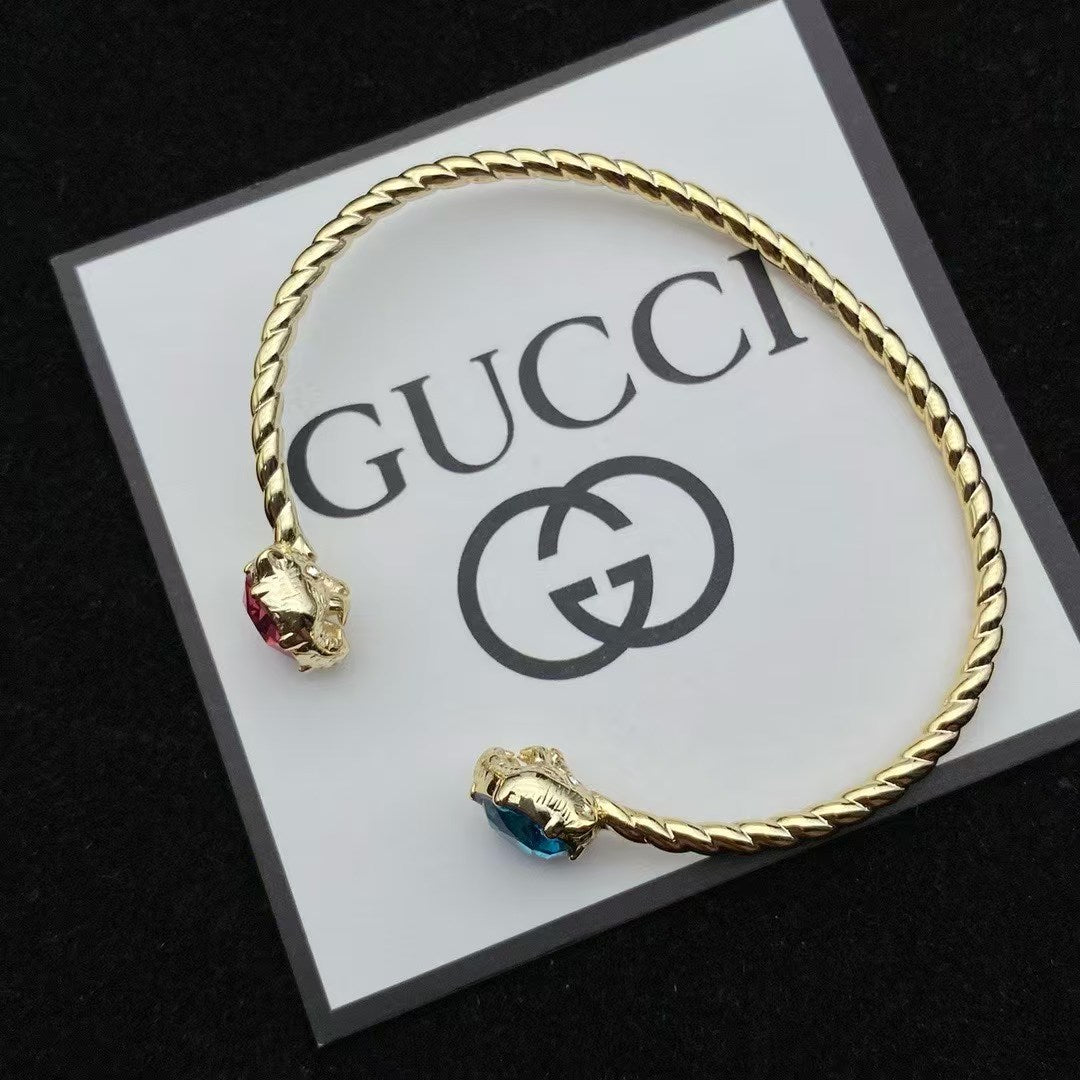 Gucci Twisted Rope Animal Head Bracelet – Gold Cuff with Pink & Blue Gemstone Details