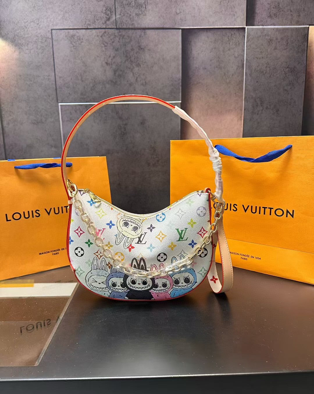 Colorful handbag with multicolor pattern on a Louis Vuitton bag and box background